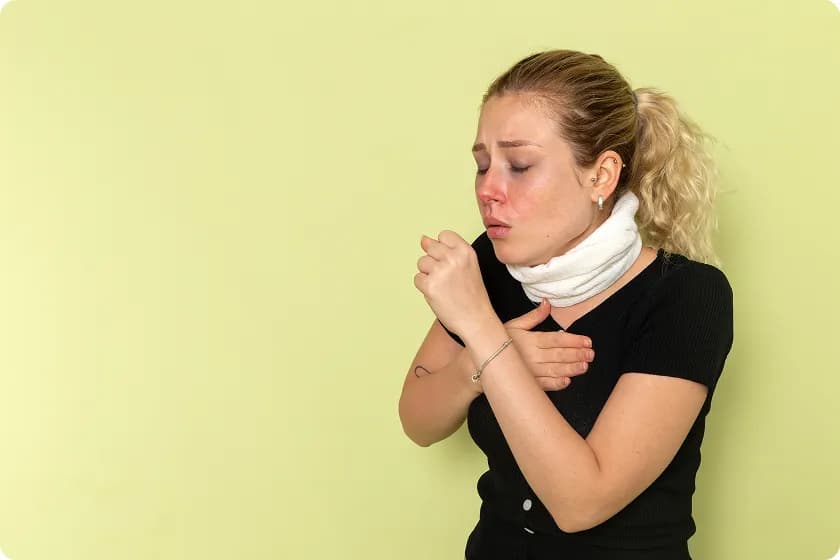 Woman coughing and covering throat due to allergy attack and throat allergy symptoms