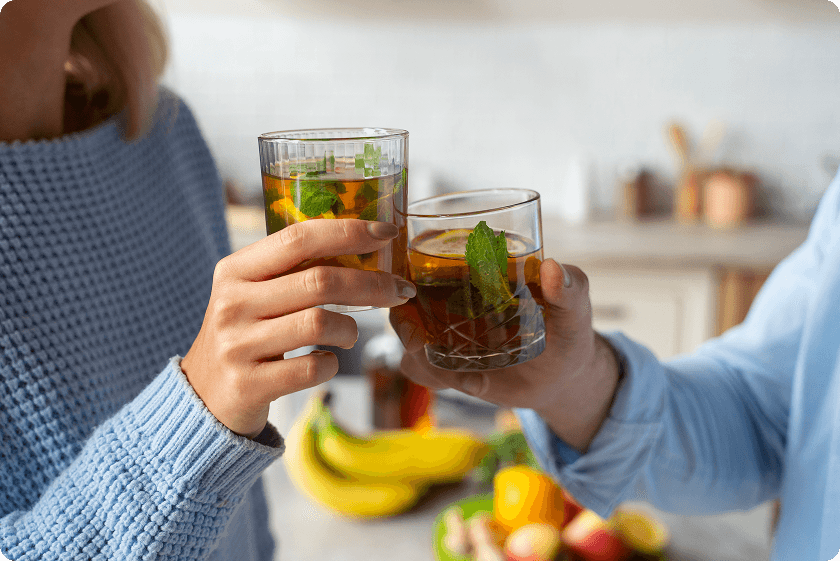 Couple sharing natural remedies for constipation with glasses of herbal mint tea.