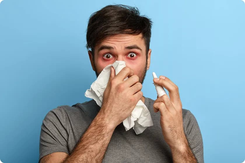 Man using nasal spray for relief from dust allergy and dust mite symptoms.