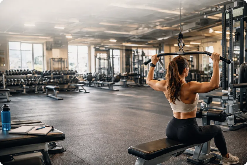 Women doing leg press and lat pulldown exercises as part of a female fitness plan.