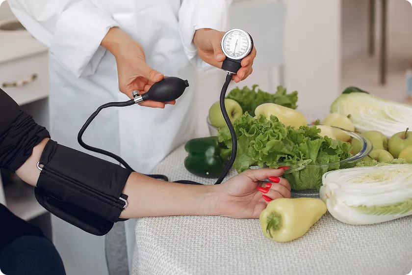 Blood pressure being measured with fresh vegetables nearby